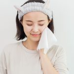 Woman drying her face with a Premium Cotton-Soft Tissue after cleansing