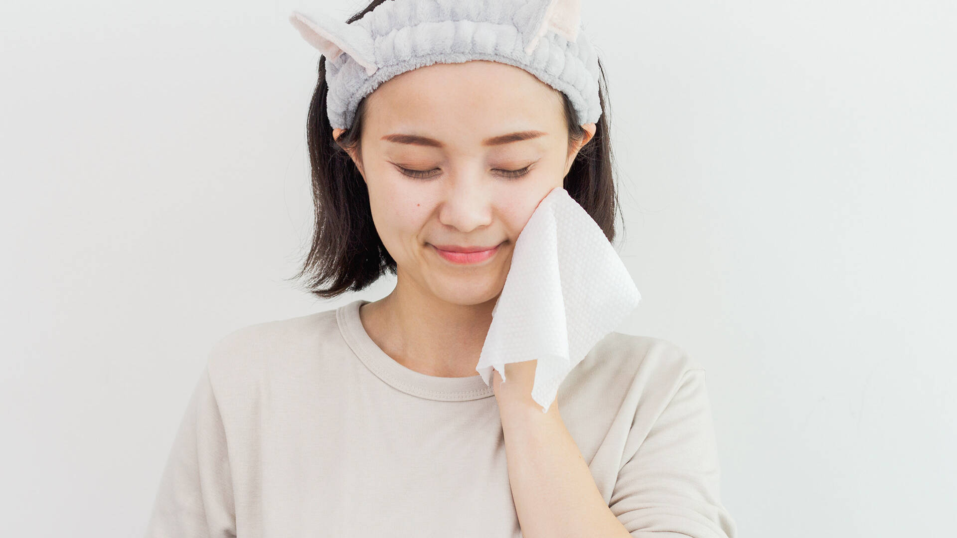 Woman drying her face with a Premium Cotton-Soft Tissue after cleansing