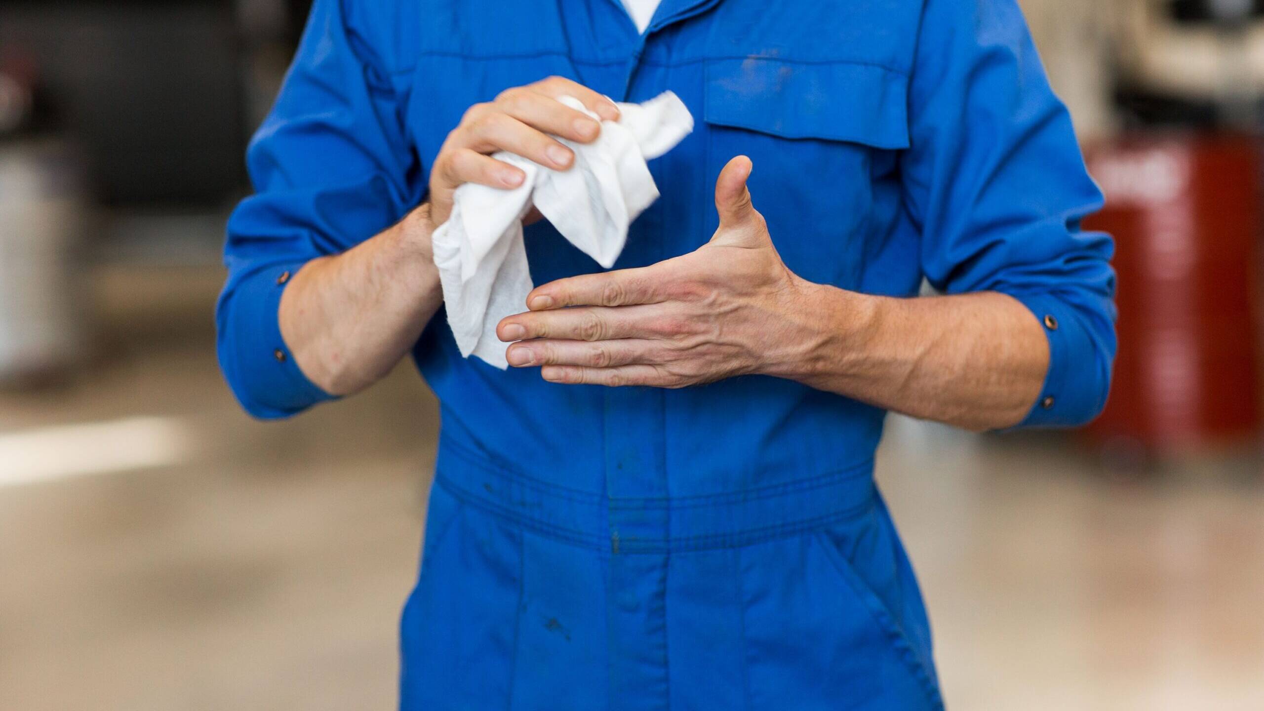 Industrial cleaning wipe removing grease from hands in a workshop