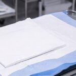 Tuala rawatan pakai buang dan alas penyerap di atas dulang klinikal keluli tahan karat