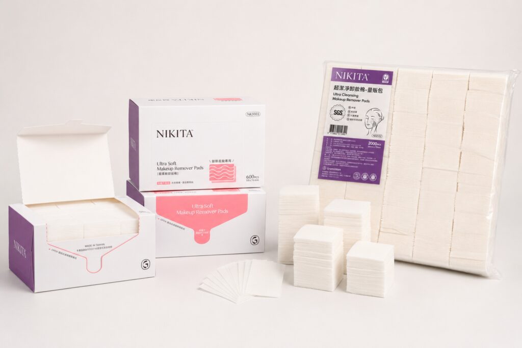 สำลีแผ่นเช็ดเครื่องสำอาง NIKITA ในกล่องบรรจุ 600 แผ่นและถุงขนาดใหญ่บรรจุ 2,000 แผ่น พร้อมสำลีแผ่นทรงสี่เหลี่ยมที่วางกระจายอยู่