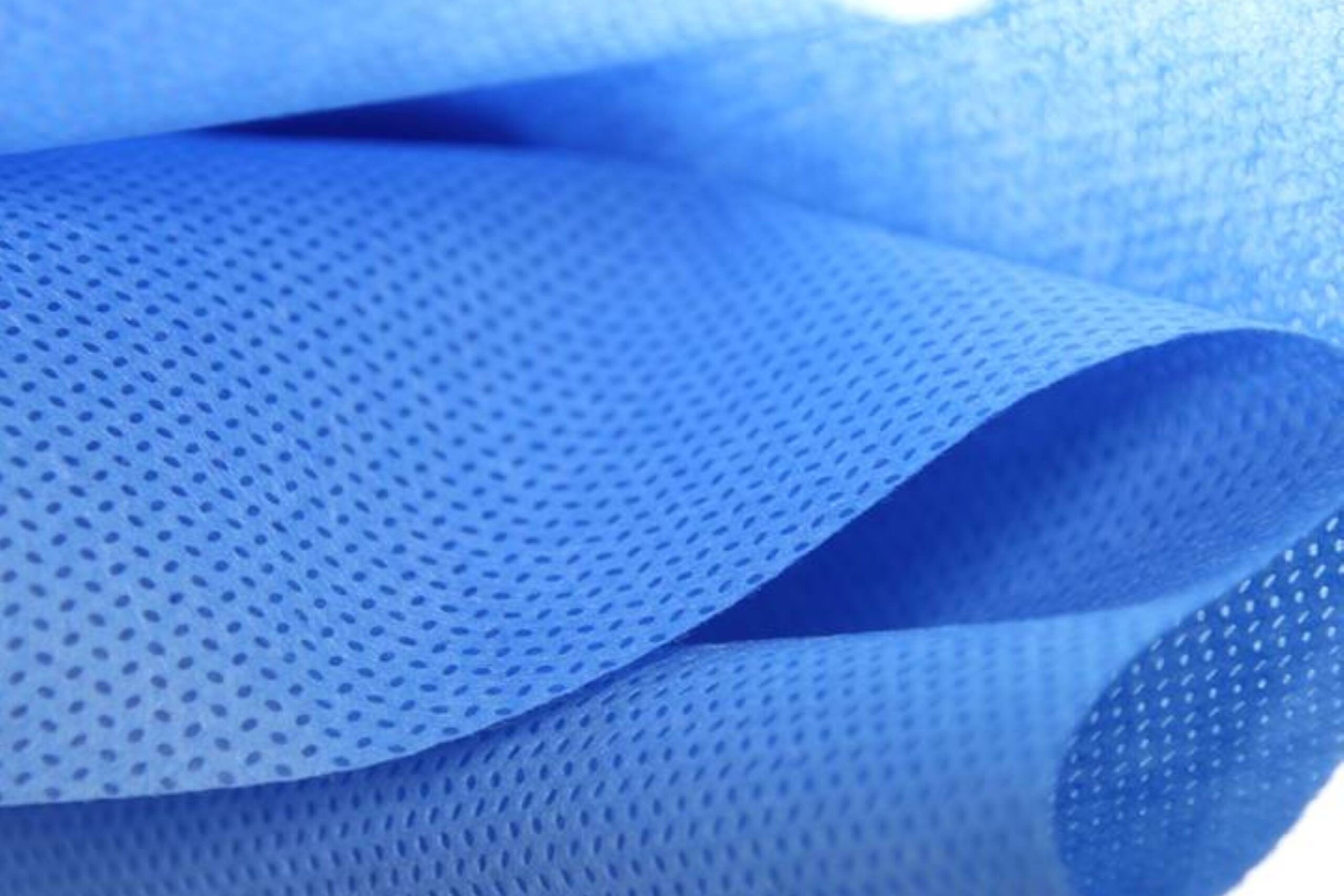 Blue SMS nonwoven drape fabric close-up showing embossed barrier texture