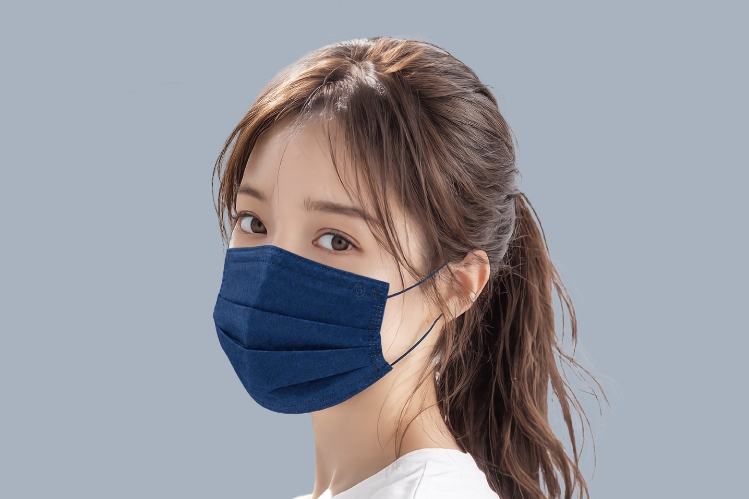 ผู้หญิงสวมหน้ากากอนามัยทางการแพทย์สำหรับผู้ใหญ่ชนิดสัมผัสเย็น โทนฟ้า หันมองข้ามไหล่