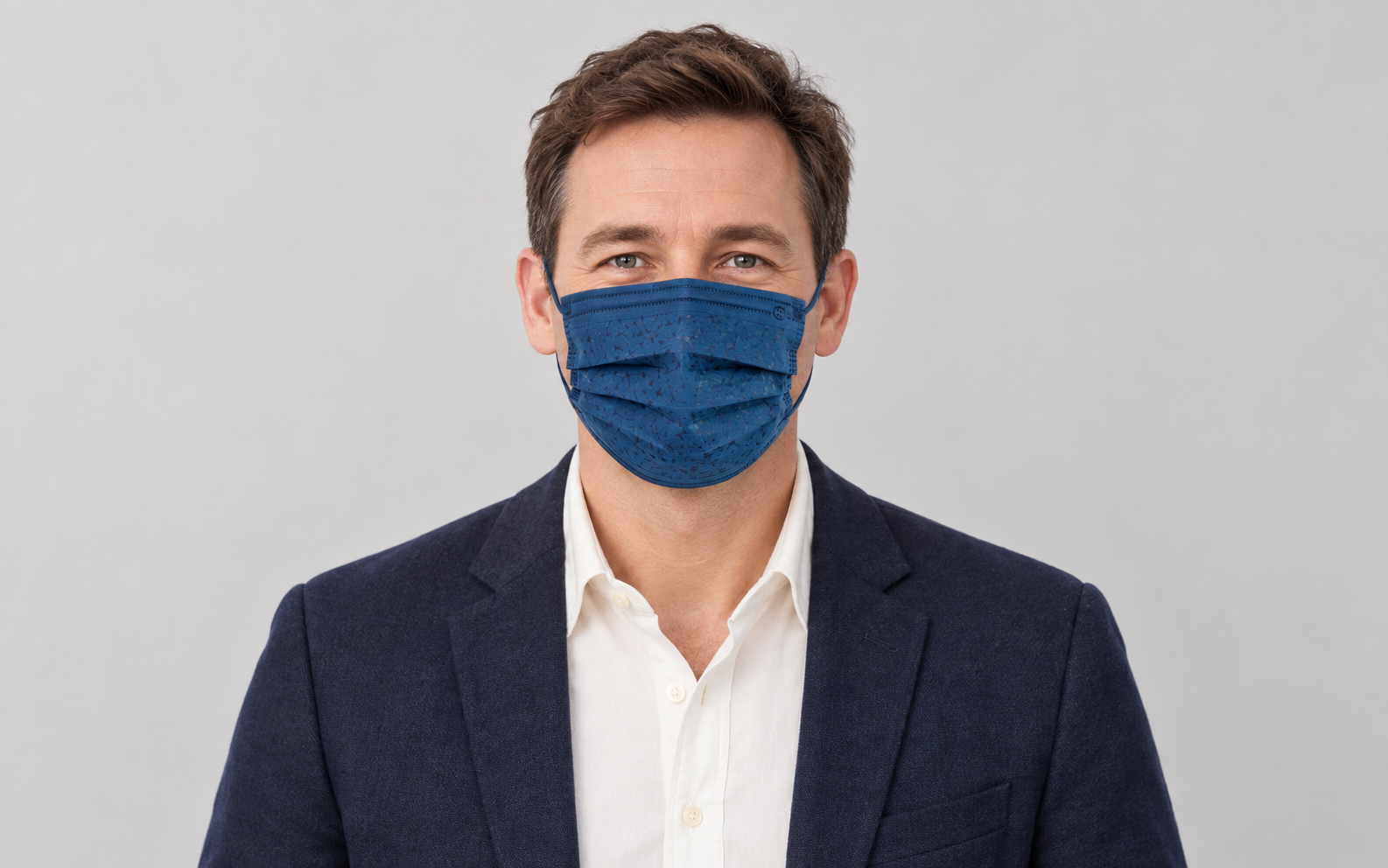 Man wearing a navy blue coral-embossed disposable face mask