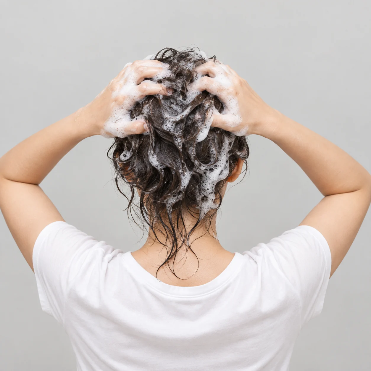 Woman lathering shampoo into her hair