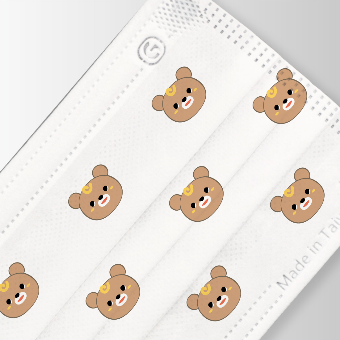 Close-up of a white pleated face mask printed with a repeating bear pattern