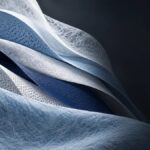 Layered white and blue nonwoven fabrics showing fibrous, apertured, and embossed textures
